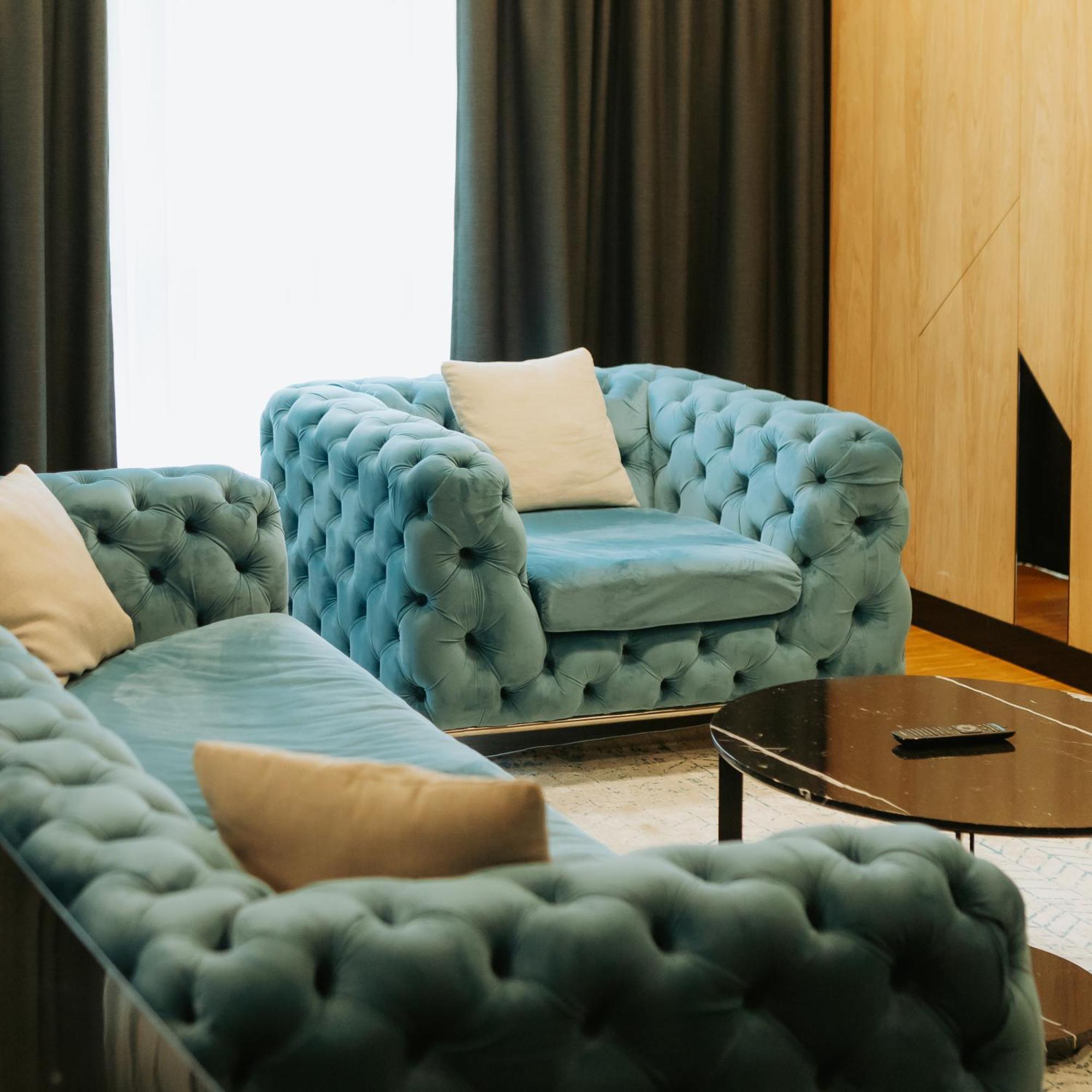Hotel Platinia Kolozsvár Kültér fotó A blue velvet Chesterfield sofa